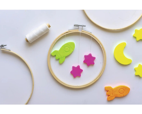 Scène avec des cerceaux à broder, bobine de fil, motifs de fusées et d''étoiles pour les travaux manuels