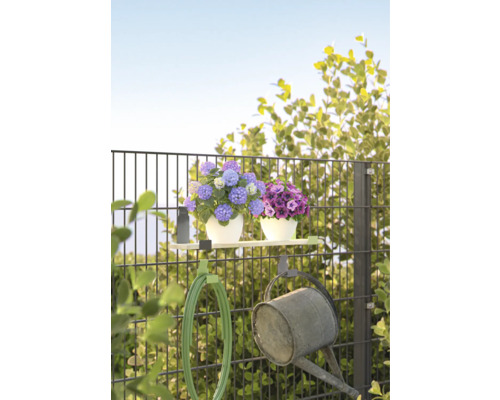 Gartenzaun mit Blumen, Gartenschlauch und Giesskanne