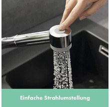 Hand betätigt Knopf am Küchenarmatur-Sprühkopf
