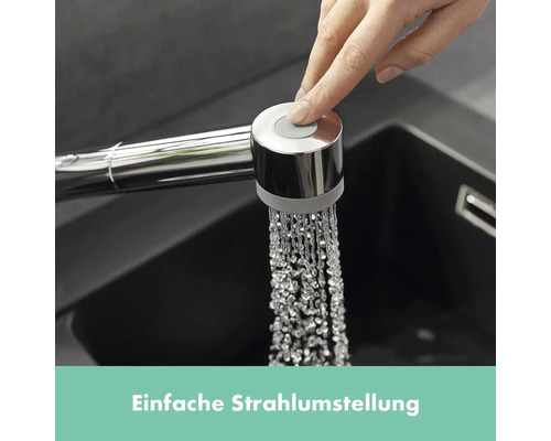 Hand betätigt Knopf am Küchenarmatur-Sprühkopf