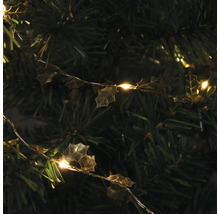 Guirlande lumineuse décorative avec feuilles de houx sur un arbre de Noël