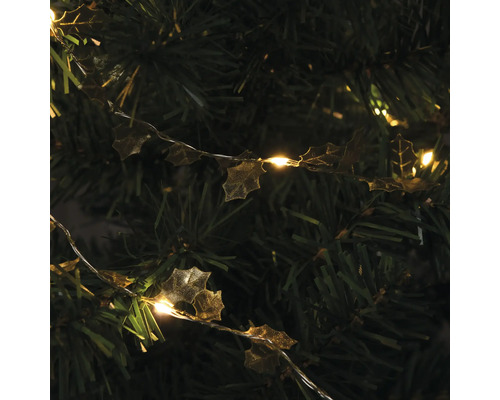 Guirlande lumineuse décorative avec feuilles de houx sur un arbre de Noël