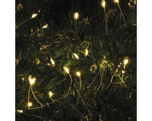 Gros plan d''une guirlande lumineuse avec des lampes LED et des boules décoratives fixée à un arbre de Noël.