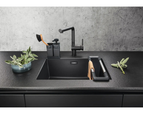 Évier de cuisine avec robinet, distributeur de savon et égouttoir dans un environnement de cuisine moderne