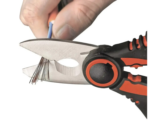 Eine Drahtlitze wird mit einer Kabelschere durchtrennt.