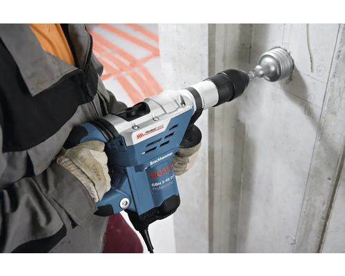 Handwerker bohrt mit einem Bosch Bohrhammer ein Loch in eine Betonwand.