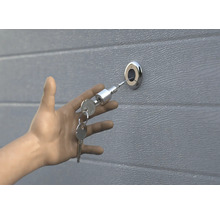 La main ouvre la porte de garage avec la clé