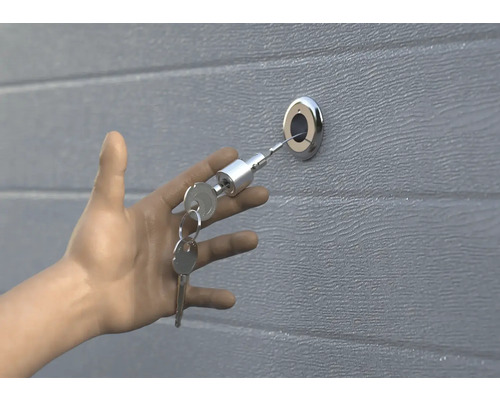 La main ouvre la porte de garage avec la clé