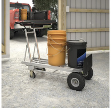 Un diable avec des seaux et un bidon se trouve dans un garage lumineux.