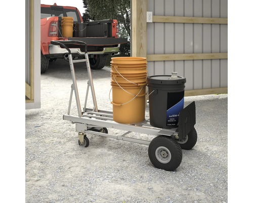 Un diable avec des seaux et un bidon se trouve dans un garage lumineux.