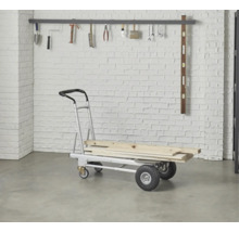 Diable avec chargement en bois devant un mur de briques avec suspension à outils