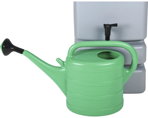 Arrosoir vert devant un réservoir d''eau