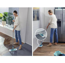 Frau wischt mit einem Mopp einen Boden in einem Haus.