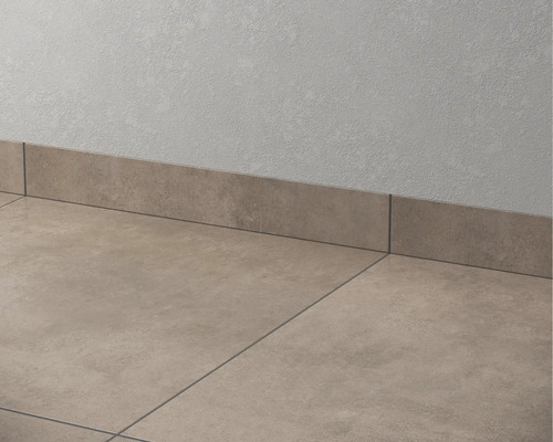 Carrelage de sol et plinthes en céramique contre un mur