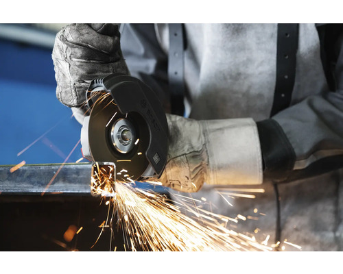 Eine Person verwendet einen Winkelschleifer zum Schneiden von Metall, wobei Funken fliegen.