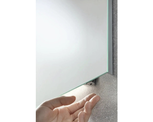 Rechteckiger Badezimmerspiegel mit LED-Beleuchtung und Hand im Bild