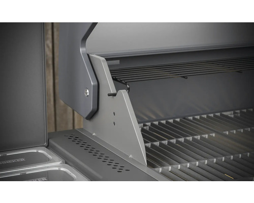 Vue détaillée d''un gril à gaz ouvert avec grille et support de maintien au chaud