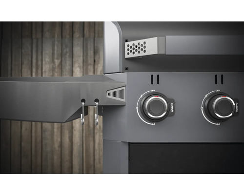 Detailansicht eines Holzkohlegrills mit Drehknöpfen und Ablagefläche