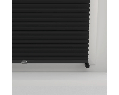 Store plissé noir dans un cadre de fenêtre pour le contrôle de la lumière et l''intimité.