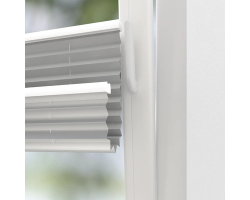 Detailansicht eines weißen Plissees am Fenster