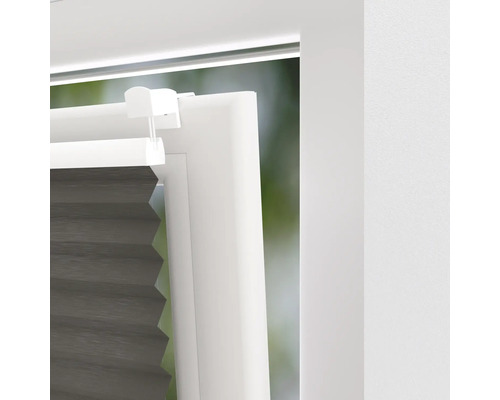 Nahaufnahme einer grauen Fensterplisseeanlage in einem weißen Fensterrahmen