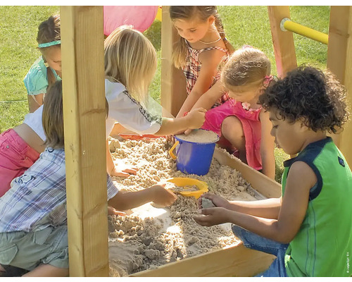 Kinder spielen im Sandkasten mit Sandspielzeug.