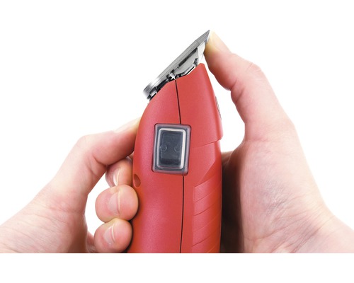 Rote Haarschneidemaschine in der Hand