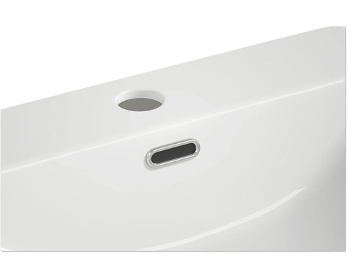 Vue détaillée d''un lavabo blanc avec trop-plein et trou de robinet