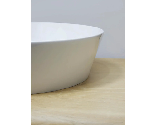 Vue détaillée d''une vasque à poser blanche sur une surface en bois clair