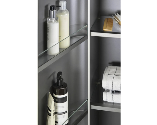 Detailansicht eines Badezimmerschranks mit Glasablagen und verschiedenen Badartikeln wie Seife, Shampoo, Handtücher und Bürste