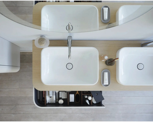 Vue de dessus d''une salle de bains avec double vasque, miroir et tiroir ouvert contenant des articles de toilette