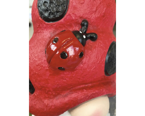 Detailaufnahme einer Gartenfigur mit Marienkäfer-Motiv