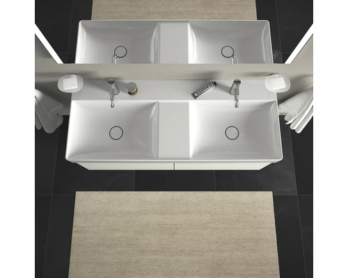 Vue de dessus d''un lavabo double avec robinets, porte-savons, serviettes et un tapis dans la salle de bain.