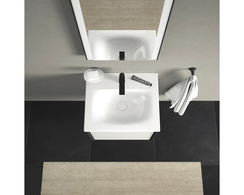 Badezimmeransicht von oben mit Waschbecken, Seife, Handtuch und Spiegel