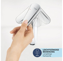 Eine Hand bedient einen Wasserhahn der Marke Grohe