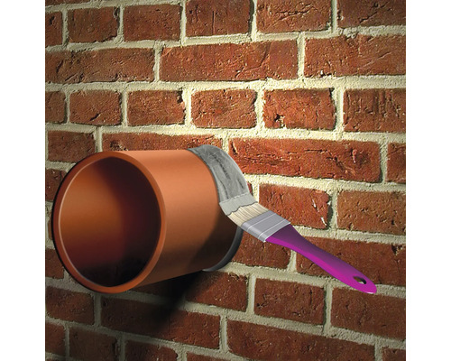 Anstreichen eines Rohrs an einer Ziegelwand mit einem Pinsel