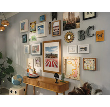 Décoration murale avec cadres, miroirs et objets de décoration au-dessus d''une console