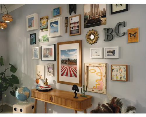 Décoration murale avec cadres, miroirs et objets de décoration au-dessus d''une console