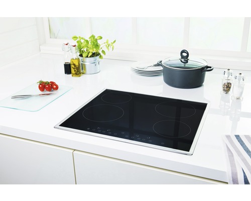 Plaque à induction dans une cuisine lumineuse avec casserole, épices et ingrédients