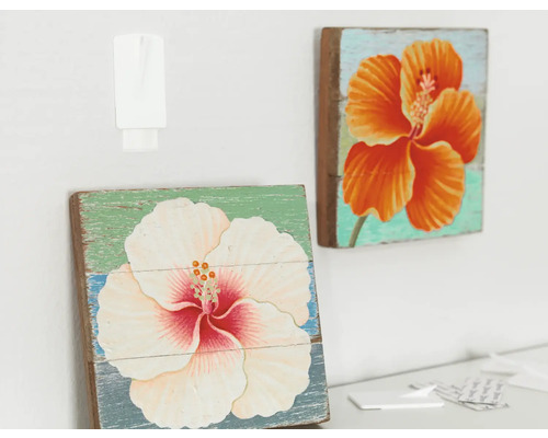 Zwei Holzbilder mit Blumenmotiven hängen an der Wand