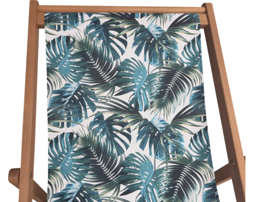 Vue détaillée d''une chaise longue avec imprimé de feuilles tropicales