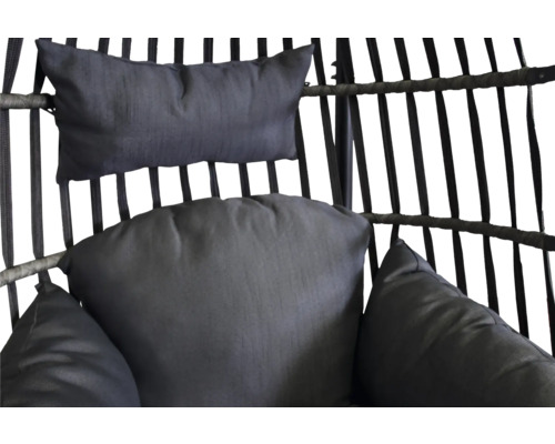 Gros plan de coussins dans un fauteuil suspendu en rotin