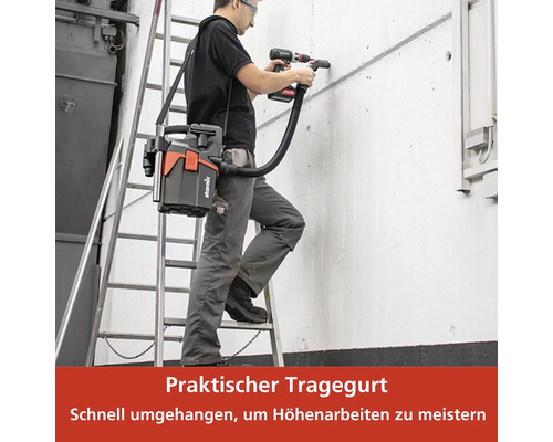 Mann bohrt mit Akkubohrer Löcher in eine Wand, während er auf einer Leiter steht und einen Staubsauger mit Tragegurt trägt.