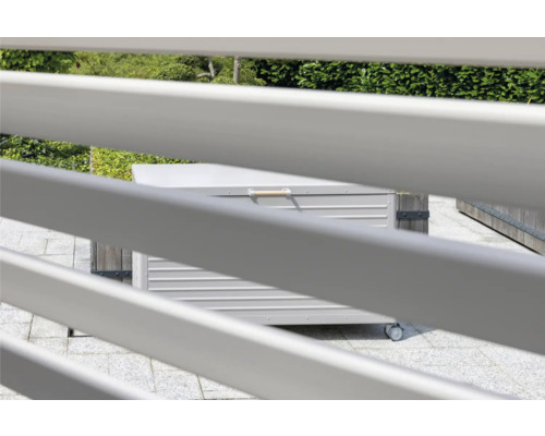 Scène de jardin avec une boîte de rangement sur roues derrière un écran d''intimité