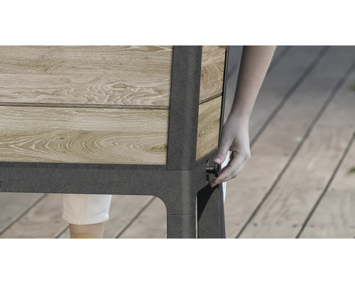 Image détaillée d''un potager surélevé en bois et en métal avec une personne actionnant un bouton