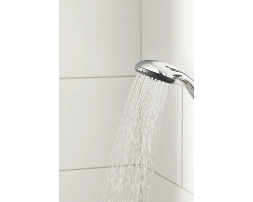 Douchette à main avec eau courante devant des carreaux muraux