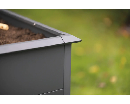 Detailansicht eines grauen Pflanzkastens mit Erde