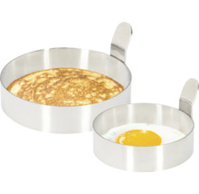 Deux moules ronds en acier inoxydable, l''un avec une omelette et l''autre avec un œuf au plat.