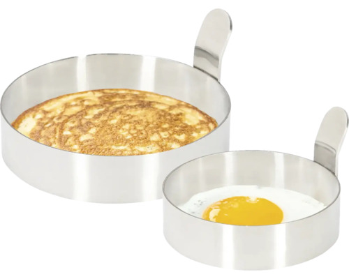 Deux moules ronds en acier inoxydable, l''un avec une omelette et l''autre avec un œuf au plat.