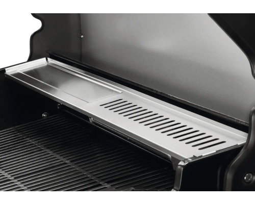 Vue intérieure d''un barbecue avec grille de maintien au chaud.